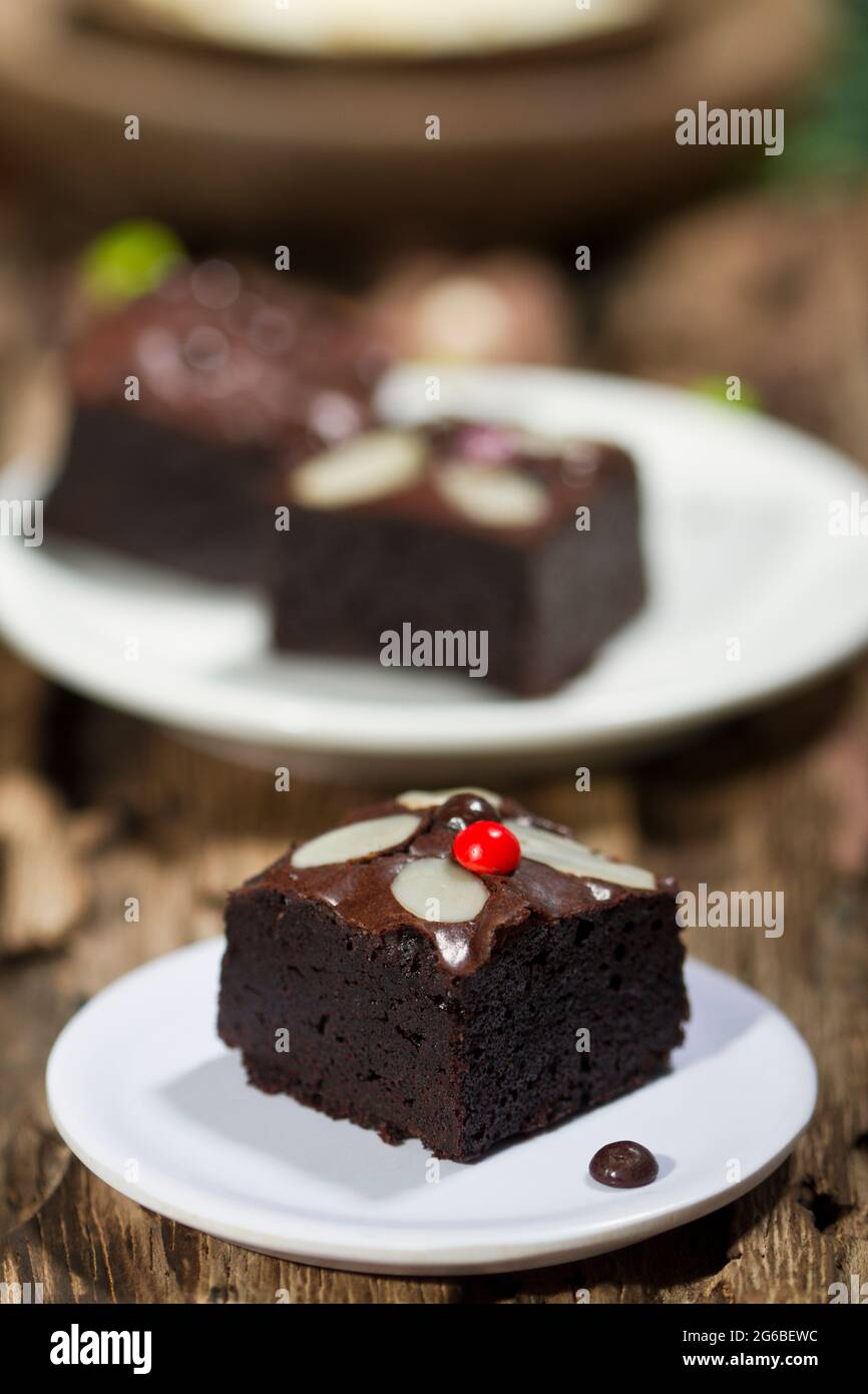 Teller aus Schokolade Brownie Quadrate mit Mandeln auf einem Holztisch Stockfoto