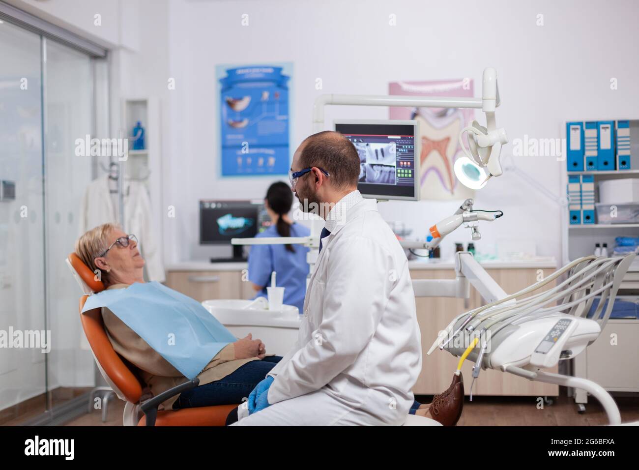 Zahnarzt suchen und untersuchen bei älteren Frau zahnärztliche Radiographie für die Behandlung. Medizinische Zahnpflege Taker hält Patienten Röntgen sitzen auf dem Stuhl während der Konsultation. Stockfoto