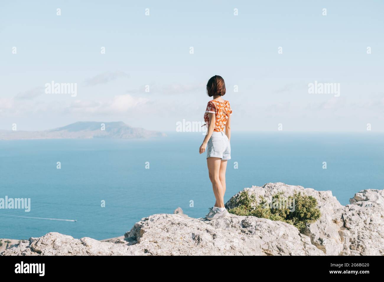 Glückliche freie Frau genießen den Meerblick. Stockfoto