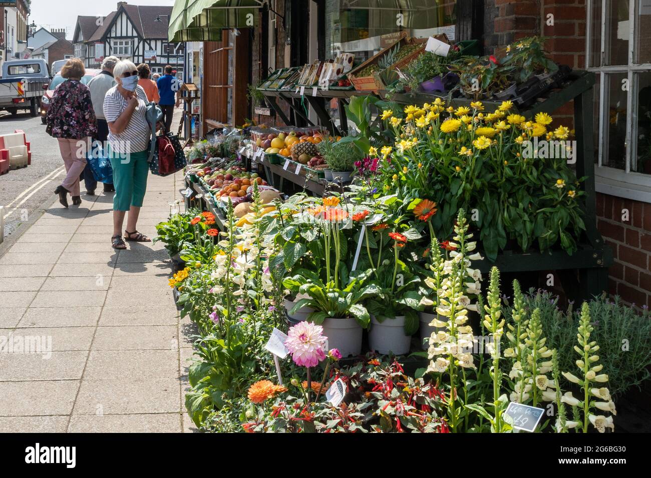 Menschen, die während der Pandemie Covid-19, Juli 2021, in einem Gemüsehändler und einem Blumengeschäft im Stadtzentrum von Emsworth, Hampshire, England, einkaufen Stockfoto