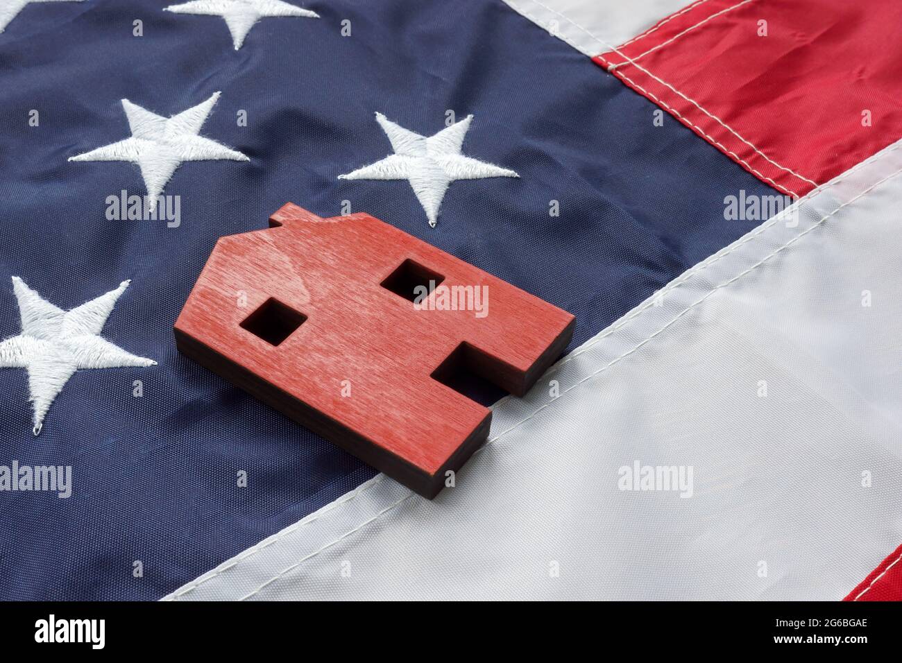 VA Rationalisierung der Refinanzierung für Darlehen zu Hause Konzept. Ein kleines Haus liegt auf der amerikanischen Flagge. Stockfoto