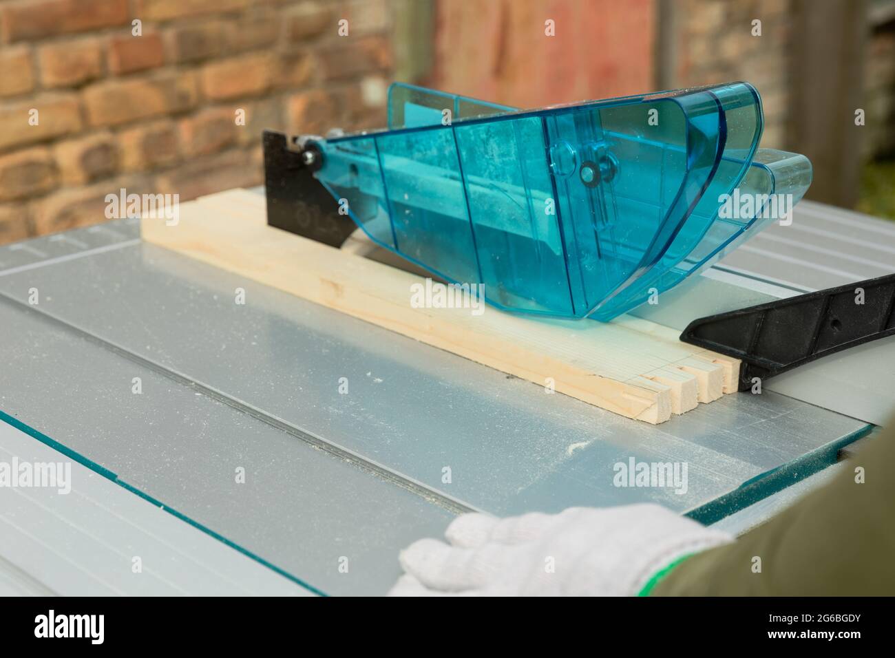 Handlicher Mann, der Holz auf einer Tischsäge schneidet. Zimmerei Holzarbeiten. Stockfoto