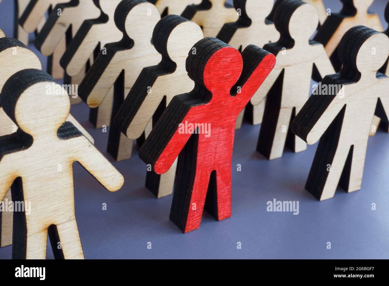 Initiative und Aktivismus Konzept. Einzigartige Figur mit erhobener Hand in einer Menschenmenge. Stockfoto