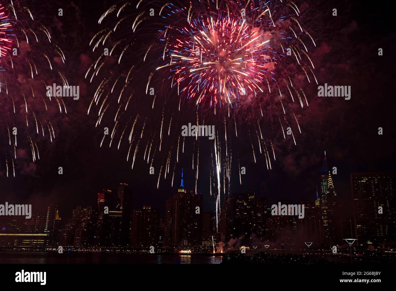 NEW YORK, NY - JULI 04: Während der 45. Jährlichen Macy's Feuerwerksvorstellung am 4. Juli, die die Skyline von Manhattan am Gantry State Plaza in Long Island City am 4. Juli 2021 im Stadtteil Queens von New York City überragt, explodieren Feuerwerke über dem East River. Als Beweis für die Verbesserung der Stadt gegenüber COVID-19 war die diesjährige Feier mit einer Laufzeit von 25 Minuten größer und länger als in den Vorjahren geplant. Aufgrund der Coronavirus-Pandemie des vergangenen Jahres wurde das Feuerwerk über vier Nächte und mehrere Bezirke verteilt, um Versammlungen zu begrenzen und die Ausbreitung zu verlangsamen. Kredit: Ron Adar/Ala Stockfoto