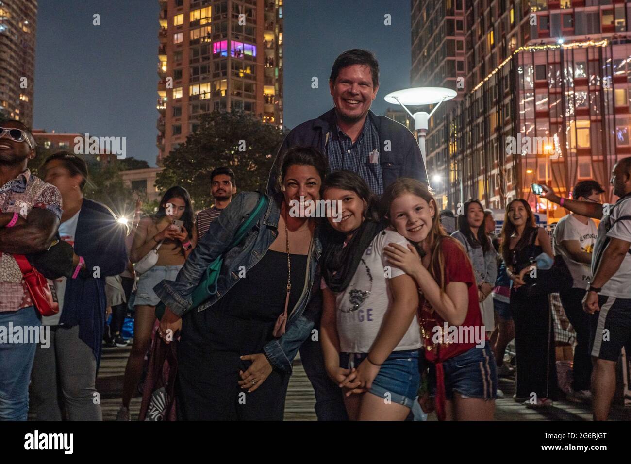 NEW YORK, NY - JULI 04: Zuschauer beobachten das Feuerwerk während der 45. Jährlichen Macy's Feuerwerksschau am 4. Juli 2021 mit Blick auf die Skyline von Manhattan am Gantry State Plaza in Long Island City im Stadtteil Queens von New York City. Als Beweis für die Verbesserung der Stadt gegenüber COVID-19 war die diesjährige Feier mit einer Laufzeit von 25 Minuten größer und länger als in den Vorjahren geplant. Aufgrund der Coronavirus-Pandemie des vergangenen Jahres wurde das Feuerwerk über vier Nächte und mehrere Bezirke verteilt, um Versammlungen zu begrenzen und die Ausbreitung zu verlangsamen. Kredit: Ron Adar/Alamy Stockfoto