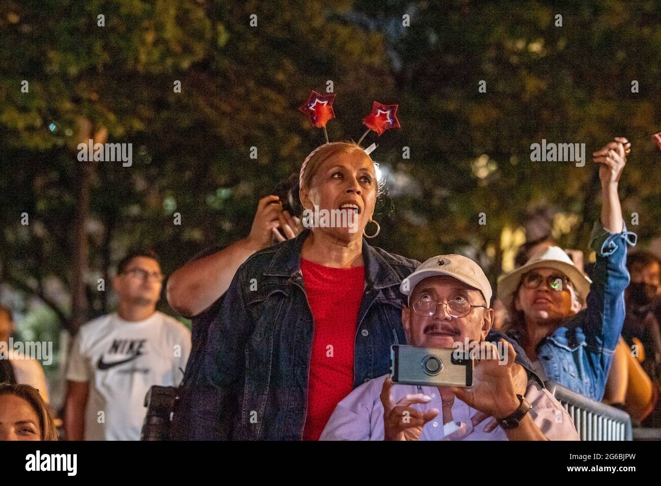 NEW YORK, NY - JULI 04: Zuschauer beobachten das Feuerwerk während der 45. Jährlichen Macy's Feuerwerksschau am 4. Juli 2021 mit Blick auf die Skyline von Manhattan am Gantry State Plaza in Long Island City im Stadtteil Queens von New York City. Als Beweis für die Verbesserung der Stadt gegenüber COVID-19 war die diesjährige Feier mit einer Laufzeit von 25 Minuten größer und länger als in den Vorjahren geplant. Aufgrund der Coronavirus-Pandemie des vergangenen Jahres wurde das Feuerwerk über vier Nächte und mehrere Bezirke verteilt, um Versammlungen zu begrenzen und die Ausbreitung zu verlangsamen. Kredit: Ron Adar/Alamy Stockfoto