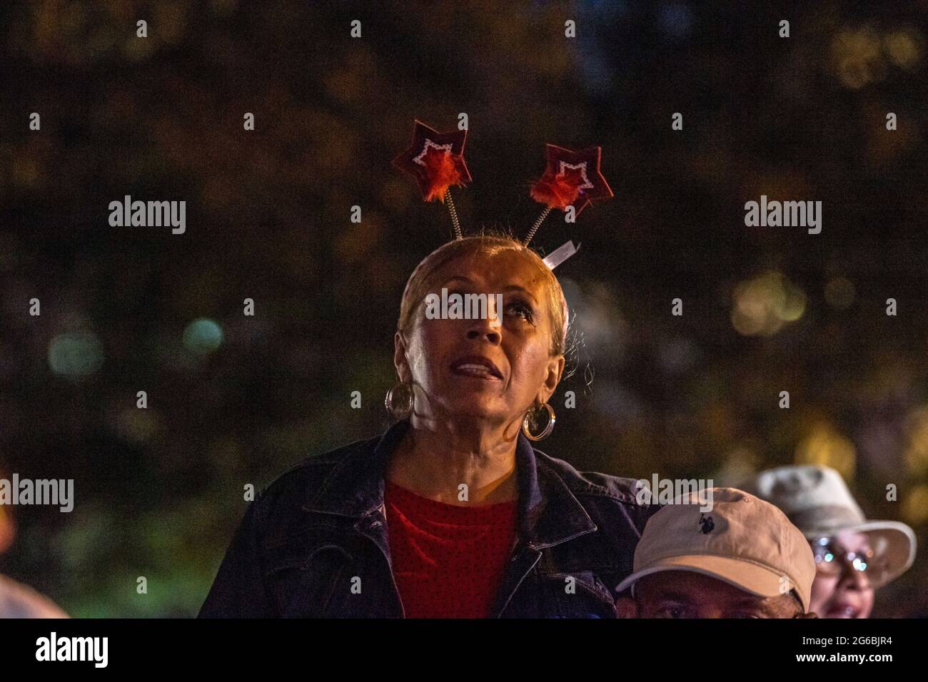 NEW YORK, NY - JULI 04: Zuschauer beobachten das Feuerwerk während der 45. Jährlichen Macy's Feuerwerksschau am 4. Juli 2021 mit Blick auf die Skyline von Manhattan am Gantry State Plaza in Long Island City im Stadtteil Queens von New York City. Als Beweis für die Verbesserung der Stadt gegenüber COVID-19 war die diesjährige Feier mit einer Laufzeit von 25 Minuten größer und länger als in den Vorjahren geplant. Aufgrund der Coronavirus-Pandemie des vergangenen Jahres wurde das Feuerwerk über vier Nächte und mehrere Bezirke verteilt, um Versammlungen zu begrenzen und die Ausbreitung zu verlangsamen. Kredit: Ron Adar/Alamy Stockfoto