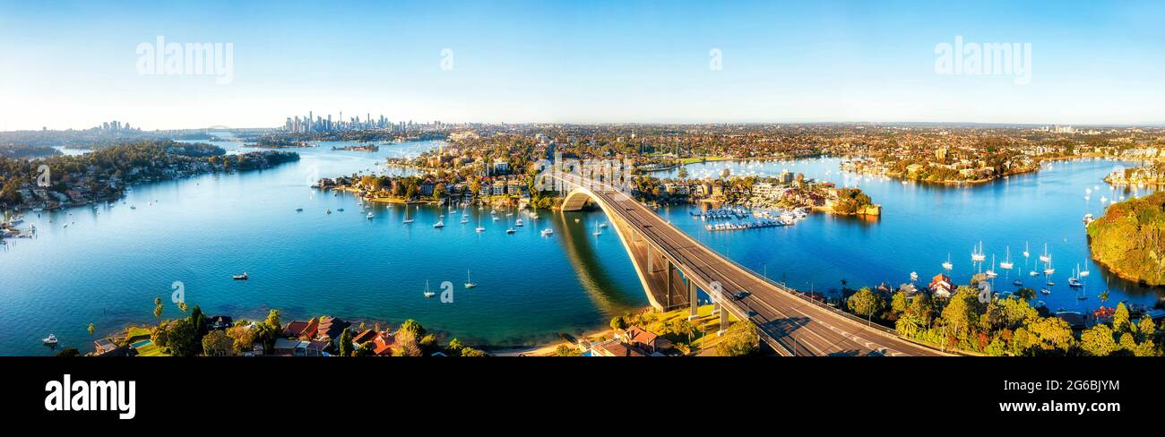 Die moderne Gladesville-Brücke über den Parramatta-Fluss nach Drummoyne mit Blick auf die Skyline der Innenstadt von Sydney - Luftpanorama. Stockfoto