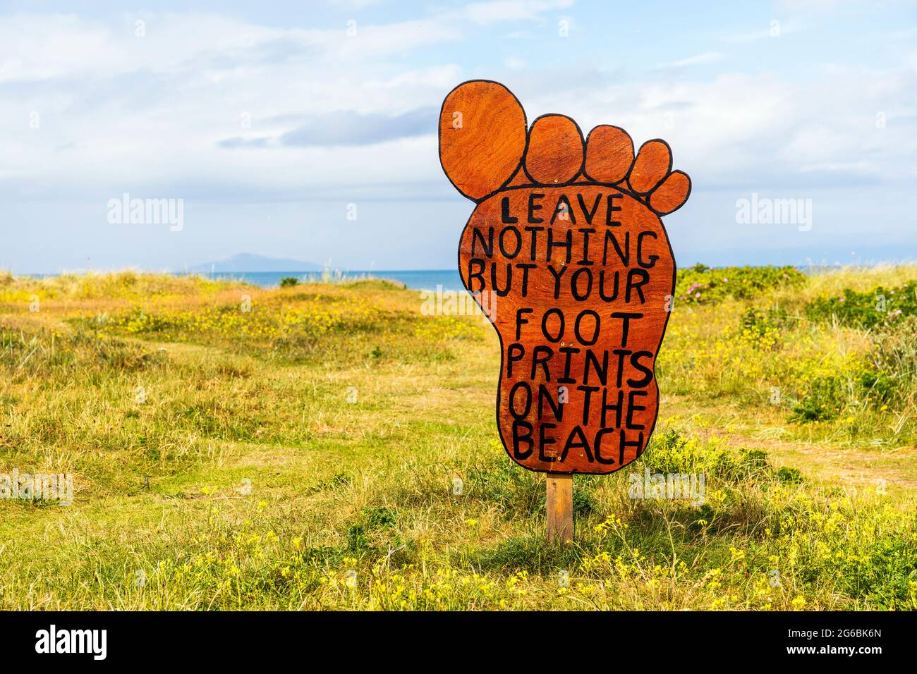 Anti-Verschmutzung-Schild in Form eines Fußes, auf dem Zufahrtsweg zum öffentlichen Strand von Troon, Ayrshire, Schottland, Großbritannien Stockfoto