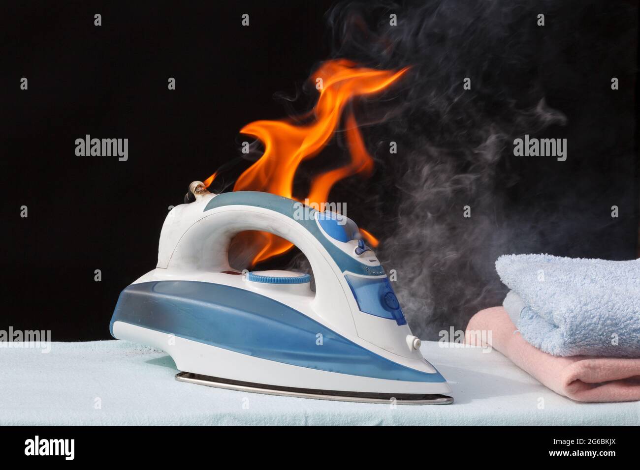 Bügeleisen auf dem Bügelbrett in Flammen Feuer Brandursache Stockfotografie  - Alamy