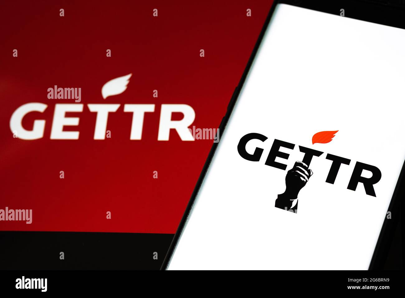 GETTR Social Network Logo auf Smartphone und verschwommenes Tablet auf dem Hintergrund. Neue Social-Media-Plattform. Stafford, Großbritannien, 5. Juli 2021: Stockfoto