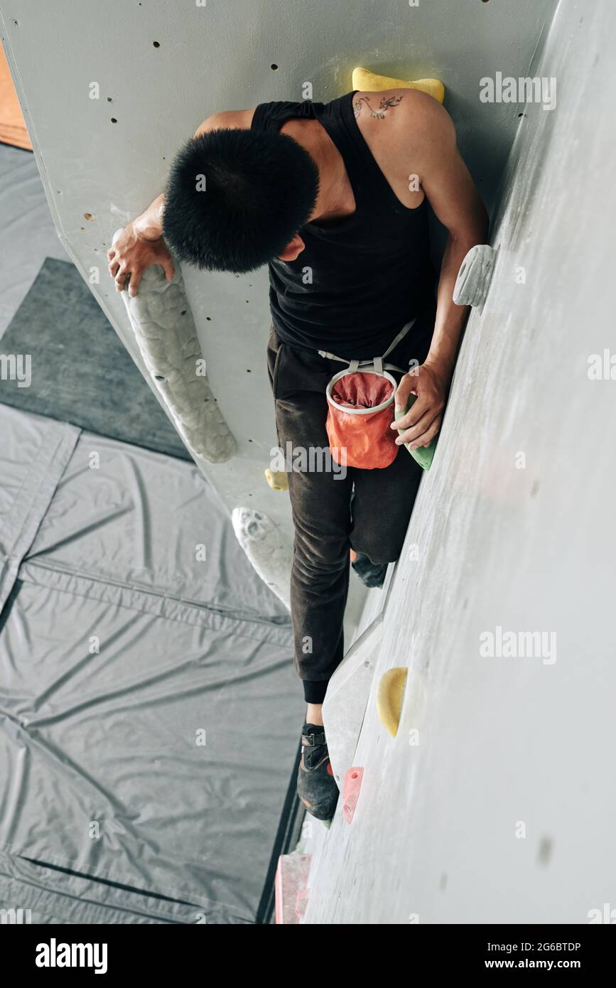 Fit junger Mann üben Klettern in Indoor-Kunstfelsen Boulderzentrum Stockfoto