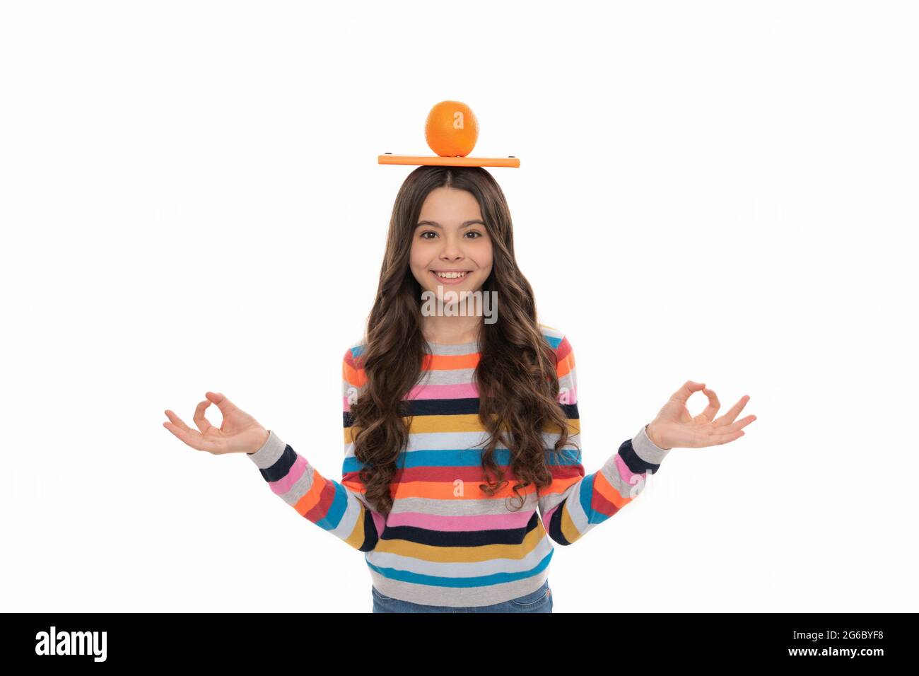 Zurück zur Schule. Wissen. Kind meditieren. Yoga. Glückliches Mädchen mit Orange und Schulnotizbuch Stockfoto