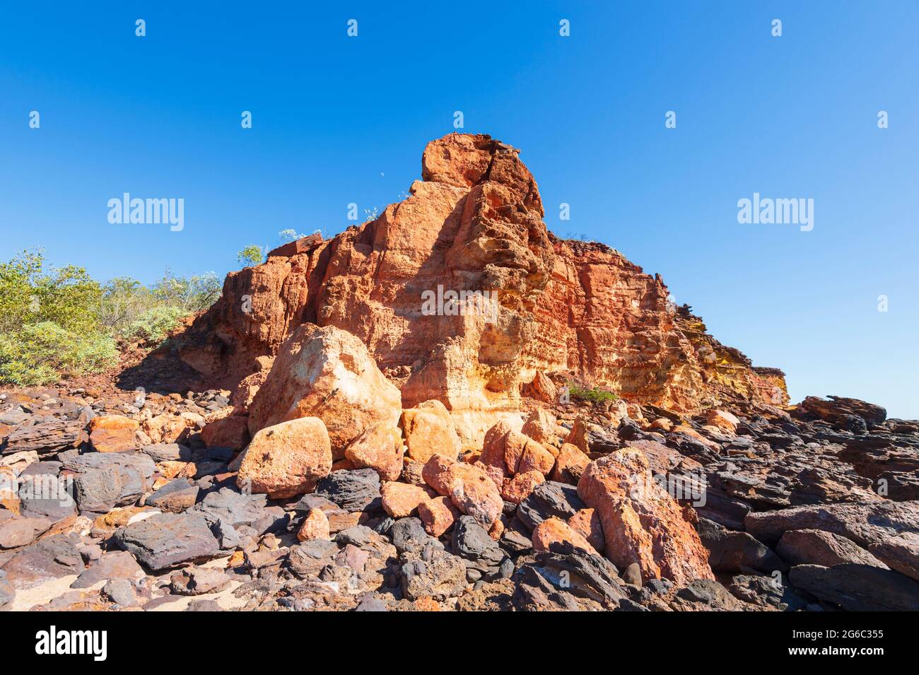 Malerischer Blick auf einen roten Pindan-Ausbiss und schwarze Felsen, Pender Bay Escape, Dampier Peninsula, Western Australia, WA, Australien Stockfoto