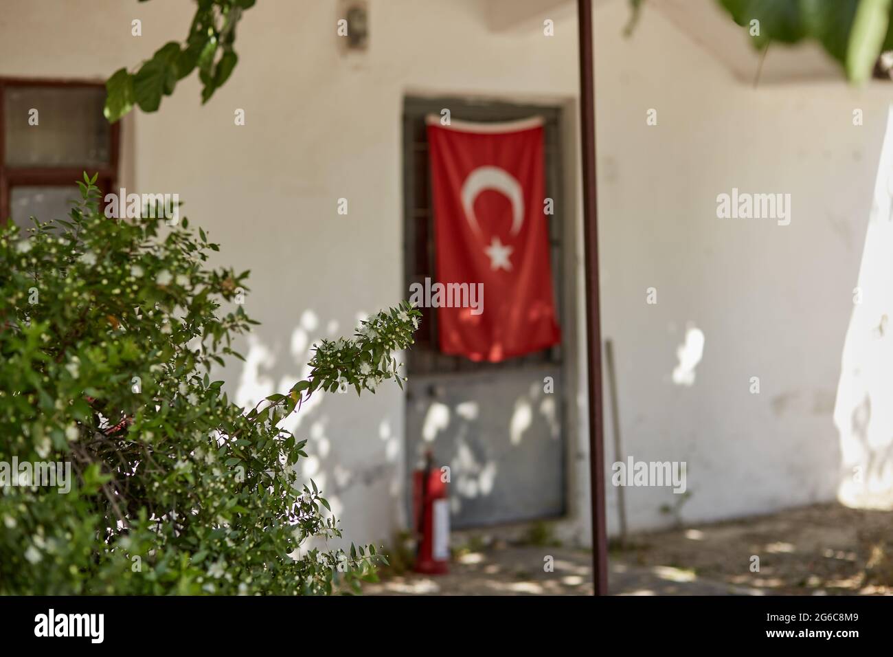 Alte türkische Provinz mit altem Haus und großer türkischer Flagge an sonnigen Tagen. Hochwertige Fotos Stockfoto