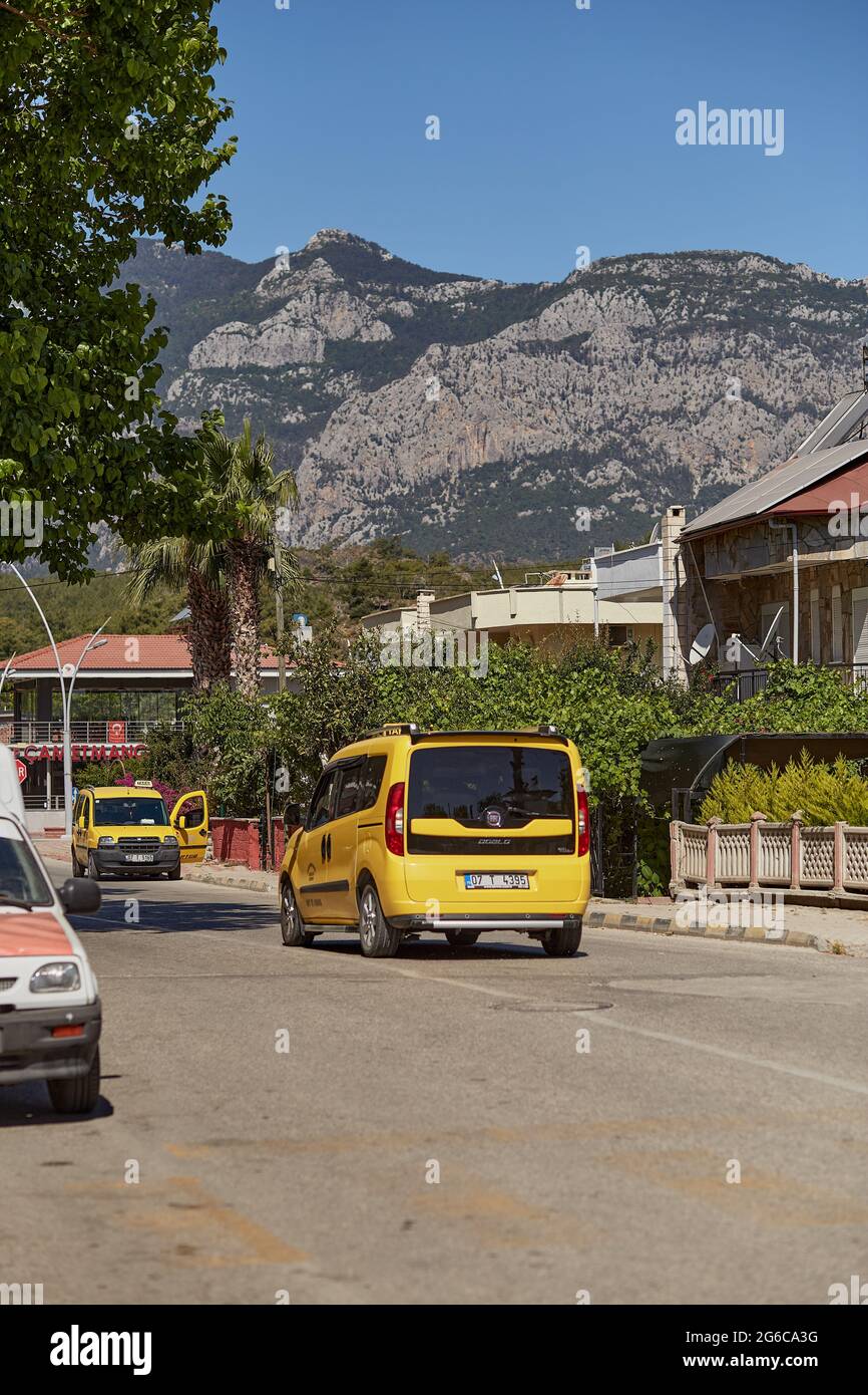 Alanya, Türkei - 24. Mai 2021: Gelbes Taxi auf der Straße an sonnigen Tagen und Blick auf die Berge. Travel Turkey Konzept Stockfoto
