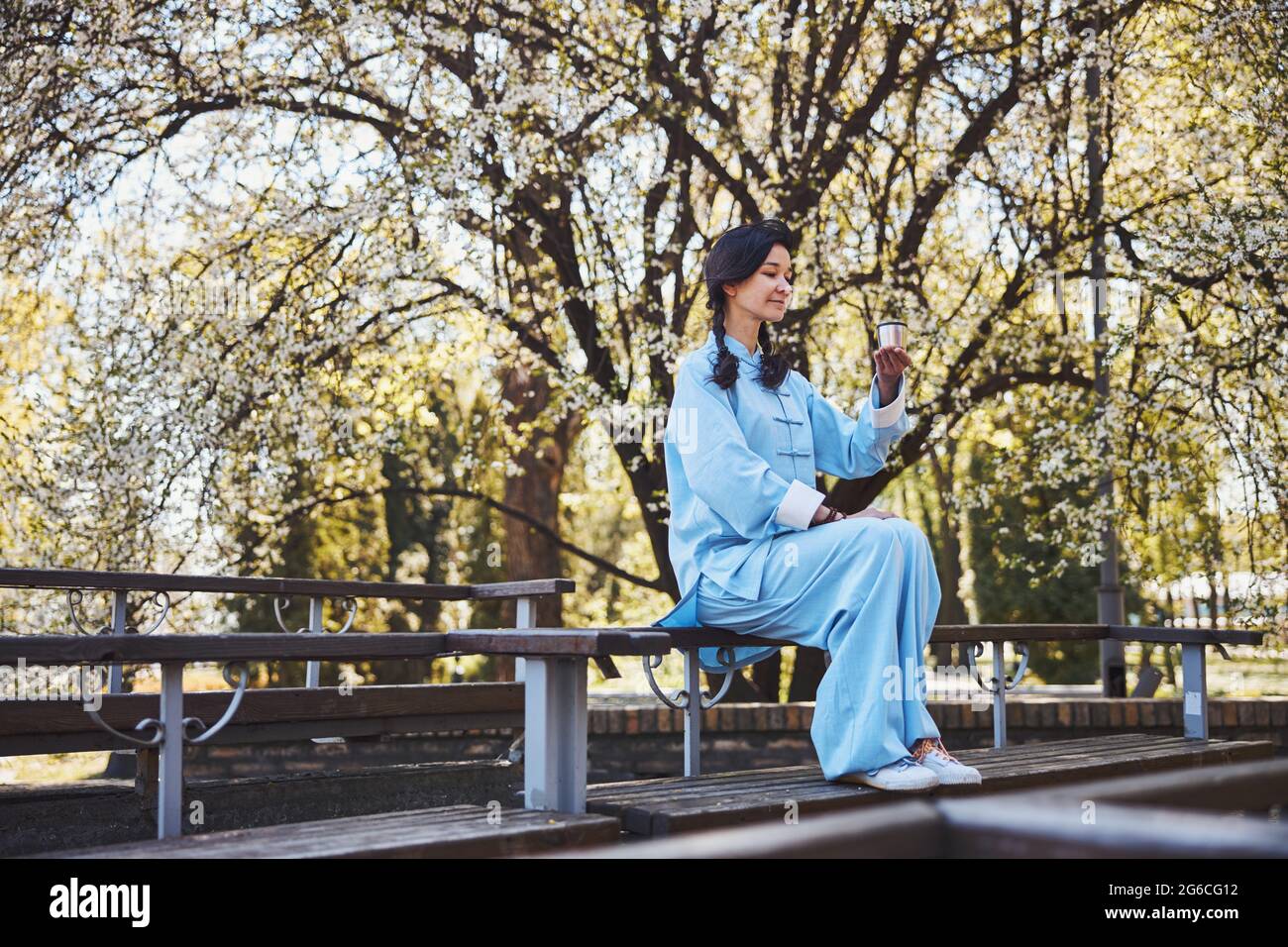 Inhalt Tai Chi Praktizierender hält eine Tasse Tee in der Hand Stockfoto
