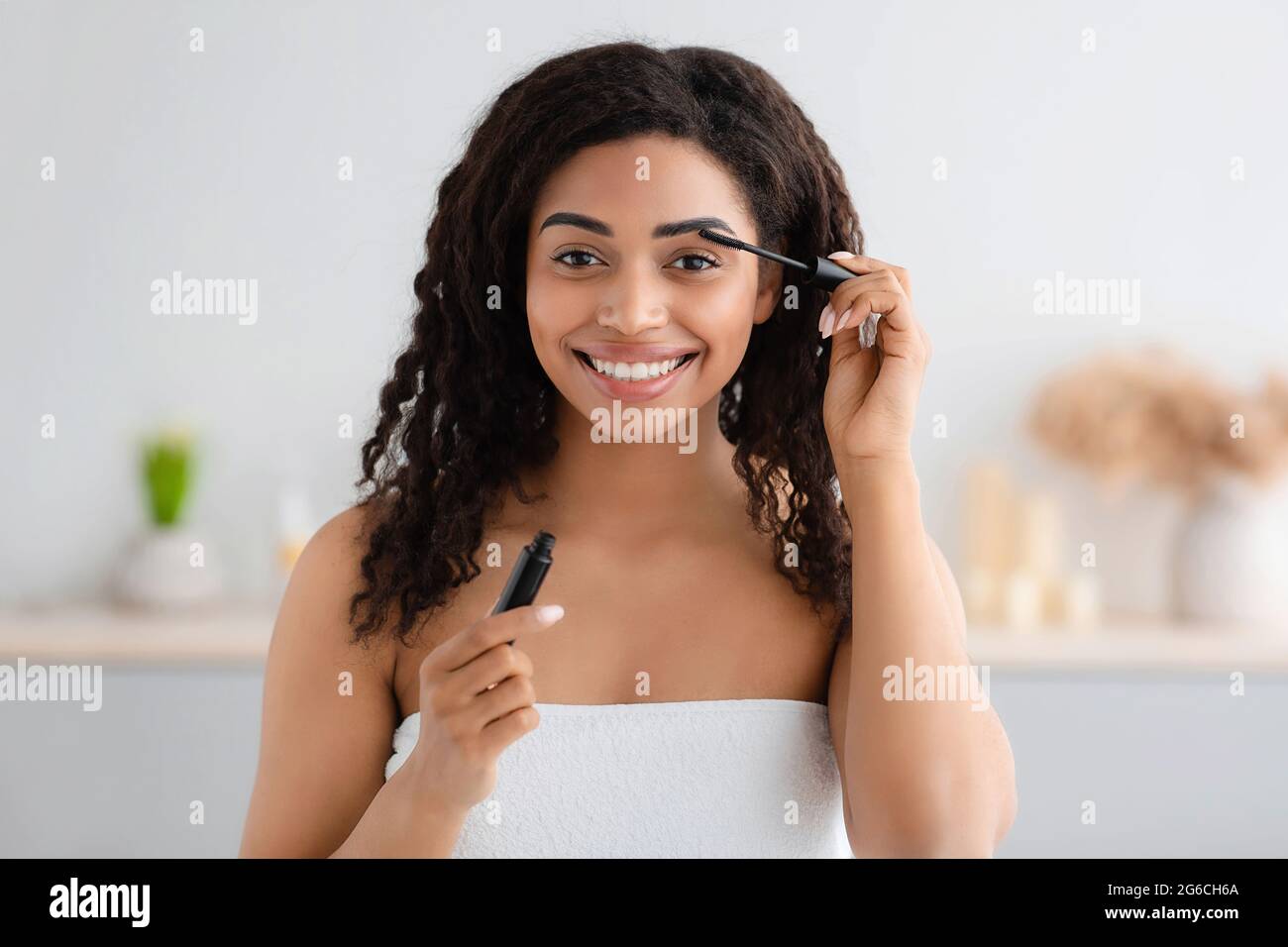 Frau macht sich bereit für die Arbeit, macht morgens Make-up-Routine im Badezimmer zu Hause Stockfoto