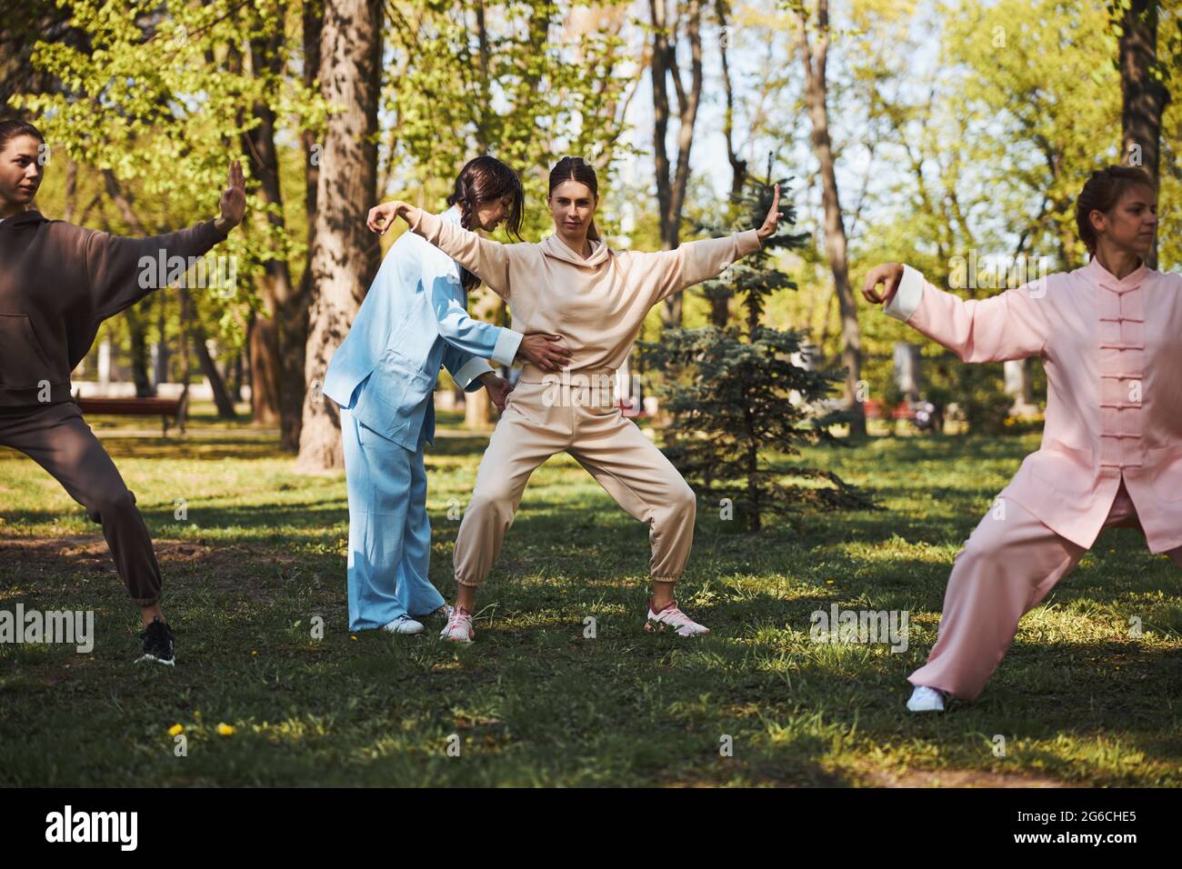 Tai Chi-Instruktor korrigiert die Haltung der Schülerin Stockfoto