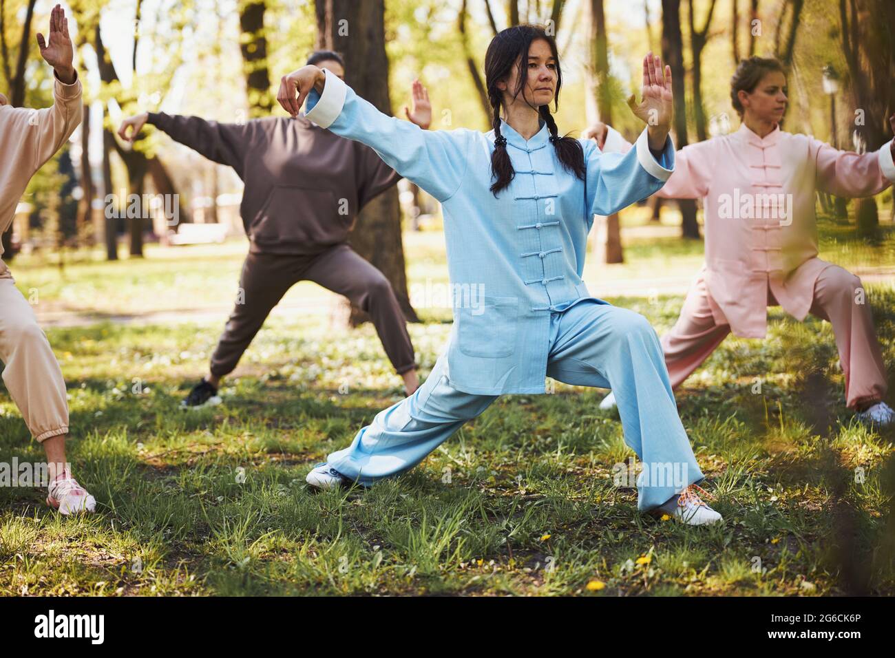 Die Taijiquan-Meisterin stellt ihren Schülern einen neuen Schritt vor Stockfoto
