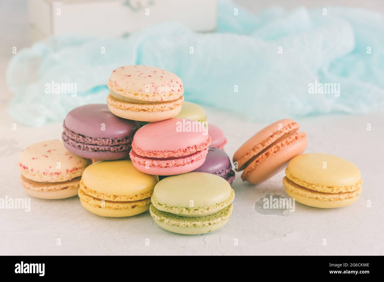 Gestapelte pastellfarbene französische Macarons vor einer weißen Wand Stockfoto