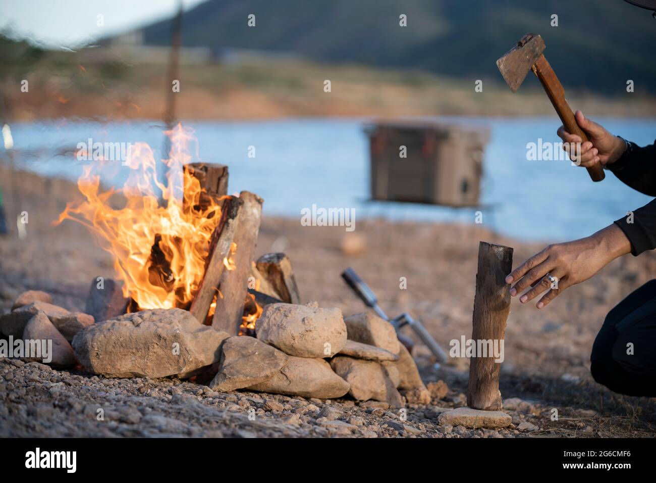 Erwachsene Mann hackt Zweige mit Axt für Lagerfeuer. Stockfoto