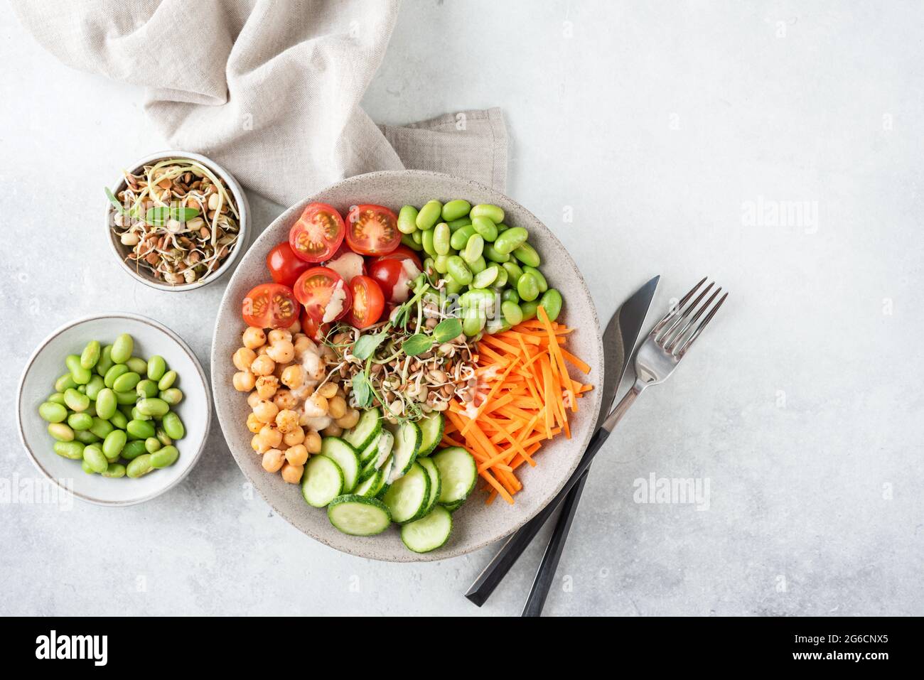 Vegane Salatschüssel Mit Kichererbsen, Gemüse, Sprossen. Buddha Schale auf grauem Betonhintergrund, Draufsicht, Kopierraum Stockfoto