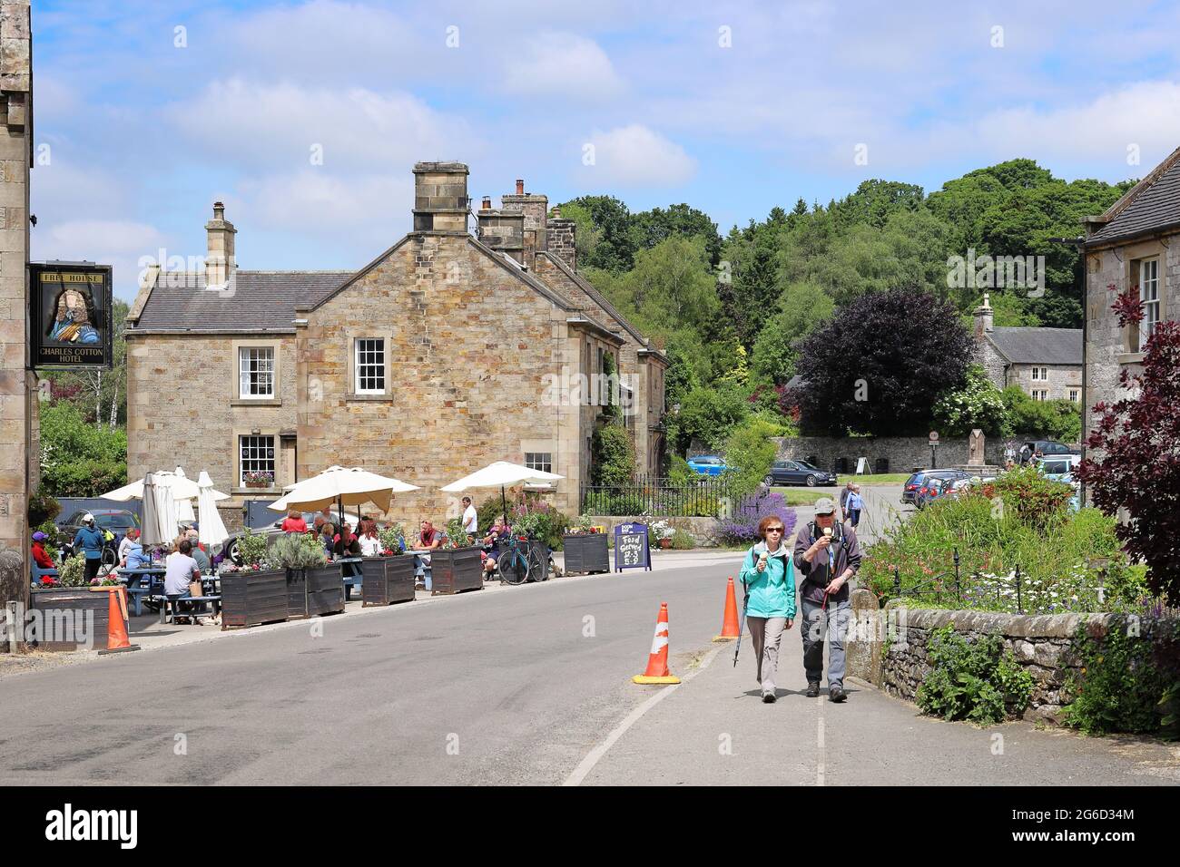 Hartington, Peak District, Derbyshire, England, Großbritannien - EIN Paar, das Eis isst, und Touristenmassen sitzen an einem Sommertag im Dorf draußen im Pub Stockfoto