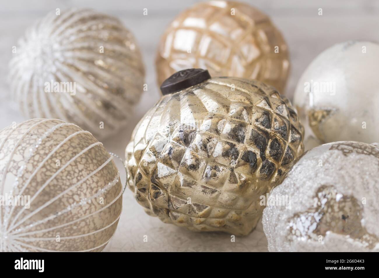 Gold und Silber schimmernde strukturierte weihnachtskugeln auf weißem Hintergrund Stockfoto