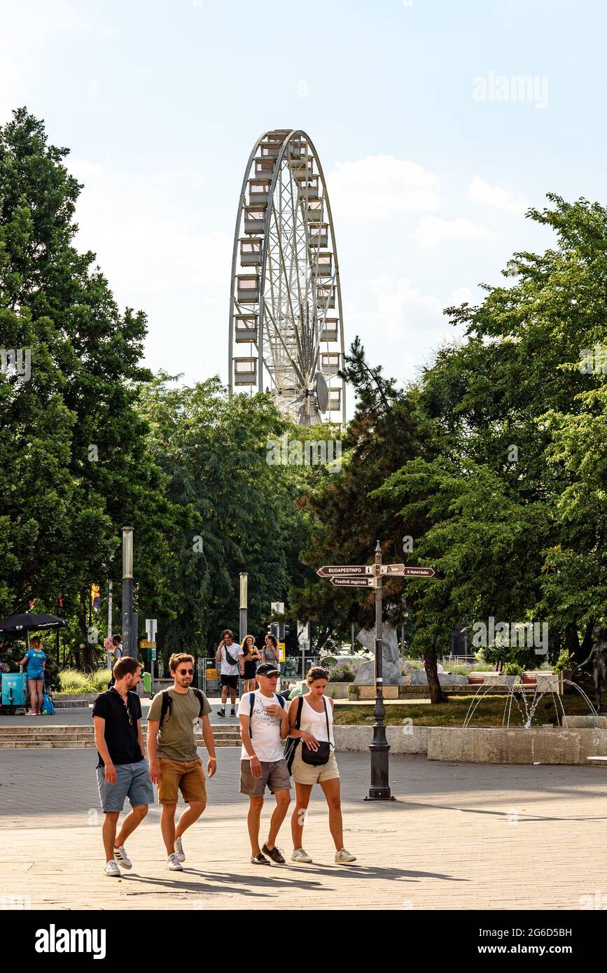 Fußgänger am Deak ter mit dem Riesenrad von Budapest Eye im Hintergrund Stockfoto