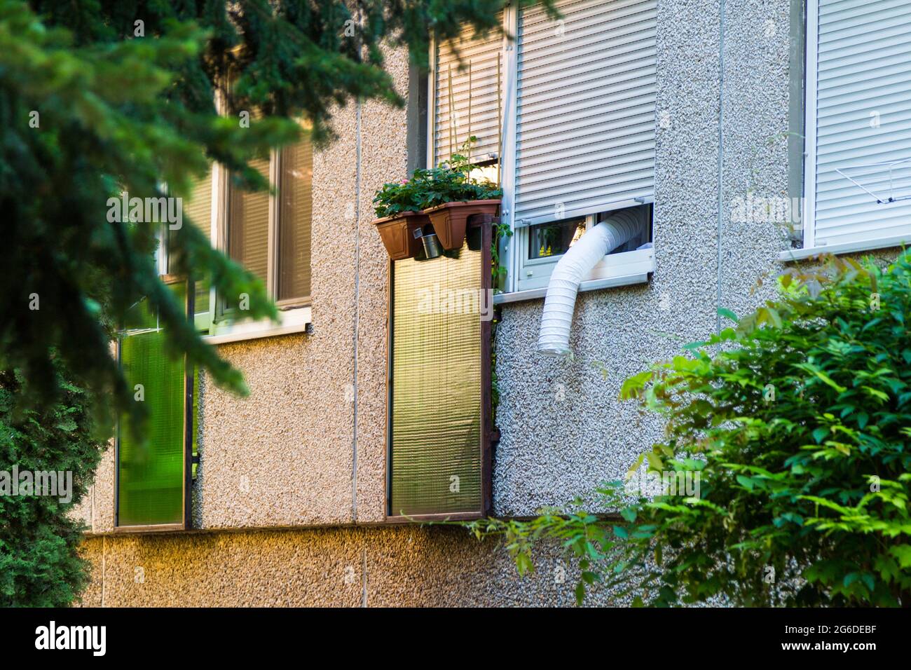Abluftschlauch für tragbare Klimaanlagen, der im Fenster des Wohnhauses in Sopron, Ungarn, hängt Stockfoto