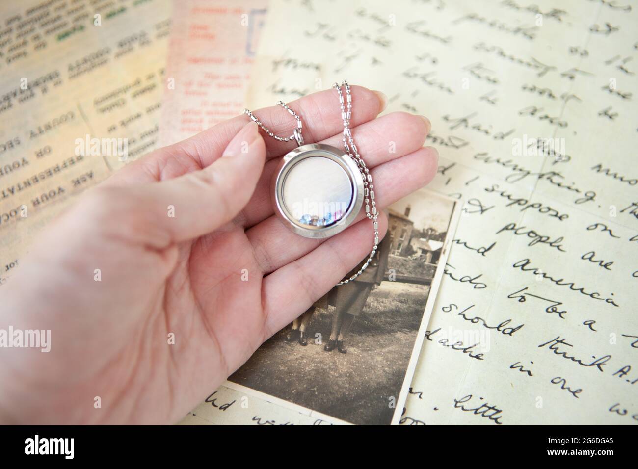 Medaillon auf der Frau Hand- hält schöne Luxus runde Medaillon auf Buchstaben und Foto-Hintergrund. Emories Konzept. Stockfoto