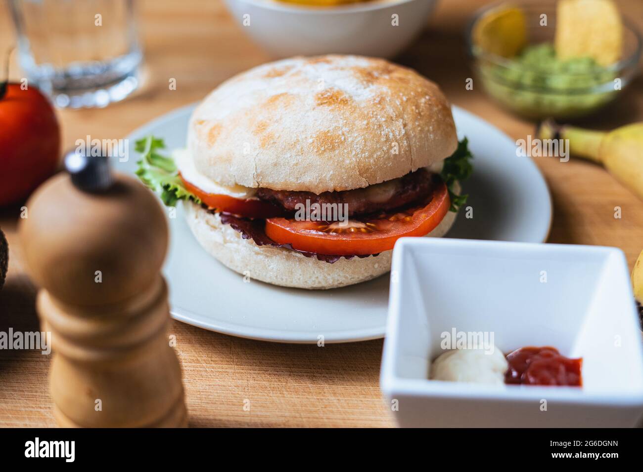 Frischer, leckerer Burger mit rustikalem Brötchen. Hintergrund der Speisen. Stockfoto