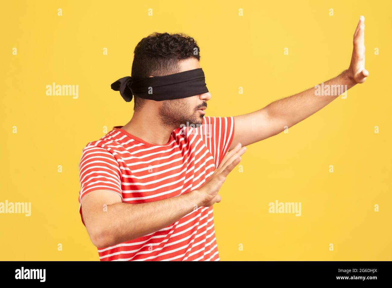 Profil Porträt bärtiger Mann mit Sehproblemen trägt schwarze Binde auf Augen, die die Hände ausstrecken, lernt durch Berührung zu navigieren, entwickelt Sinne. Stockfoto