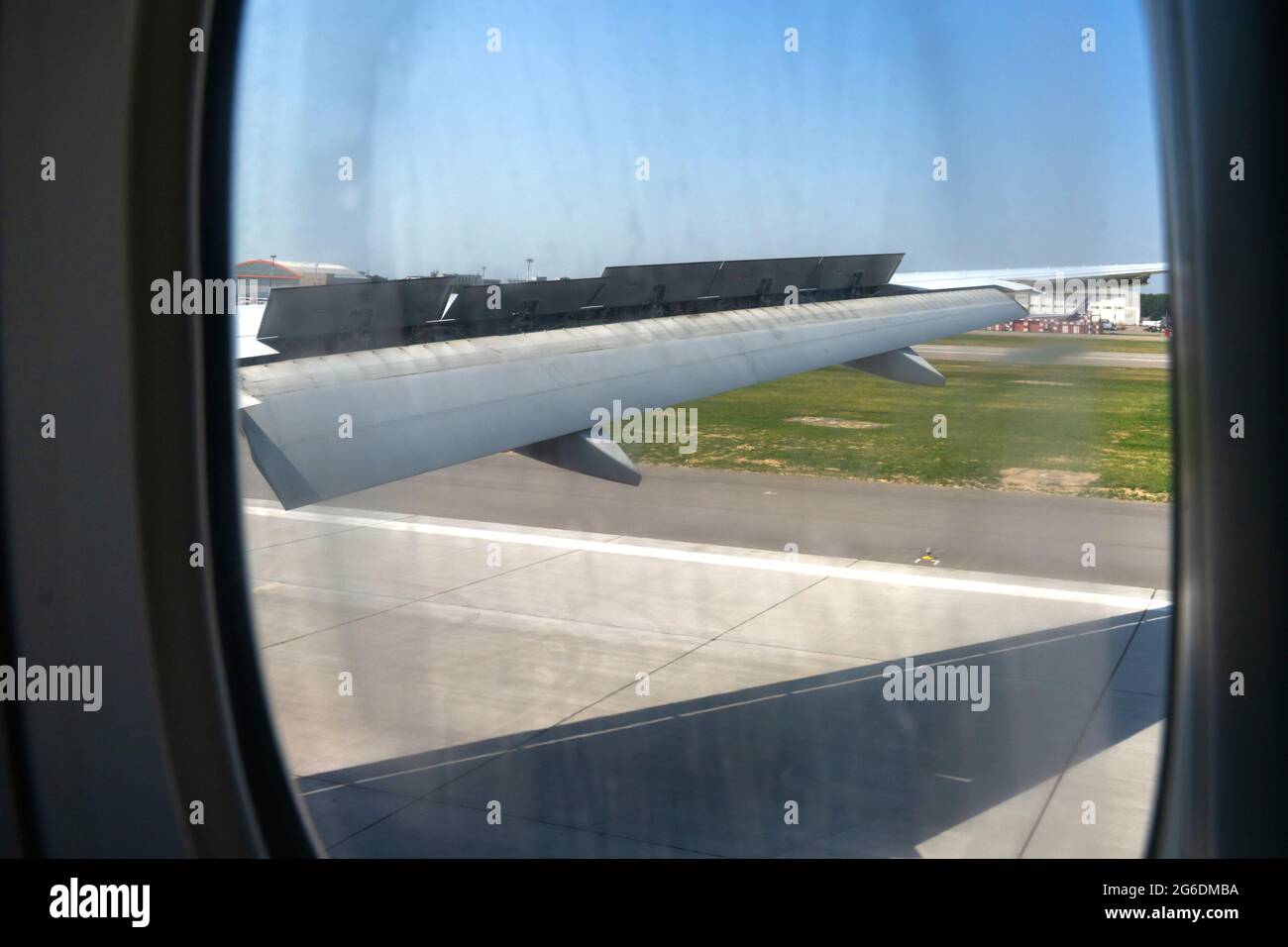 Ein Flugzeugfenster mit Blick auf Flügel und Klappen nach der Landung. Stockfoto