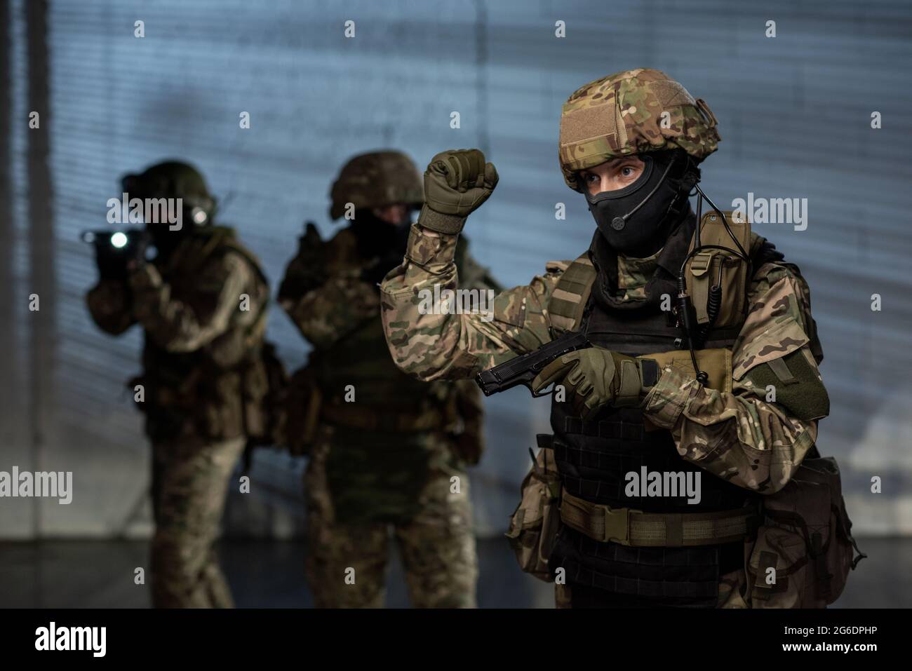 Gruppe von Männern in Tarnuniform halten Waffen Stockfoto