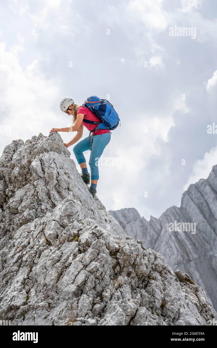 Junge Wanderin mit Helm, felsigen Bergen und Geröll, Wandern zum Hochkalter, Berchtesgadener Alpen, Berchtesgadener Land, Oberbayern Stockfoto