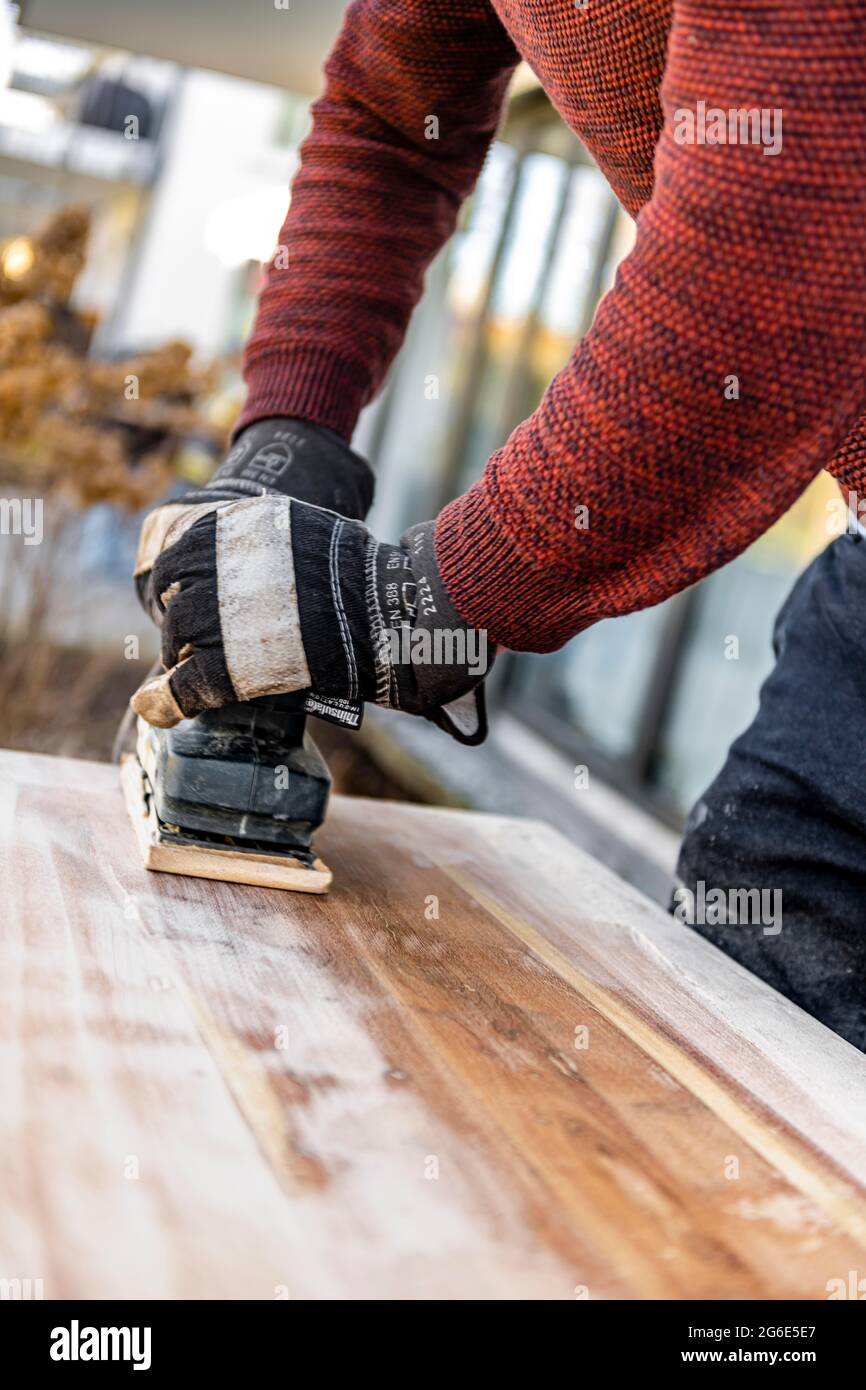 Junger Mann macht DIY, Schleiftisch mit einem Schleifer Stockfoto