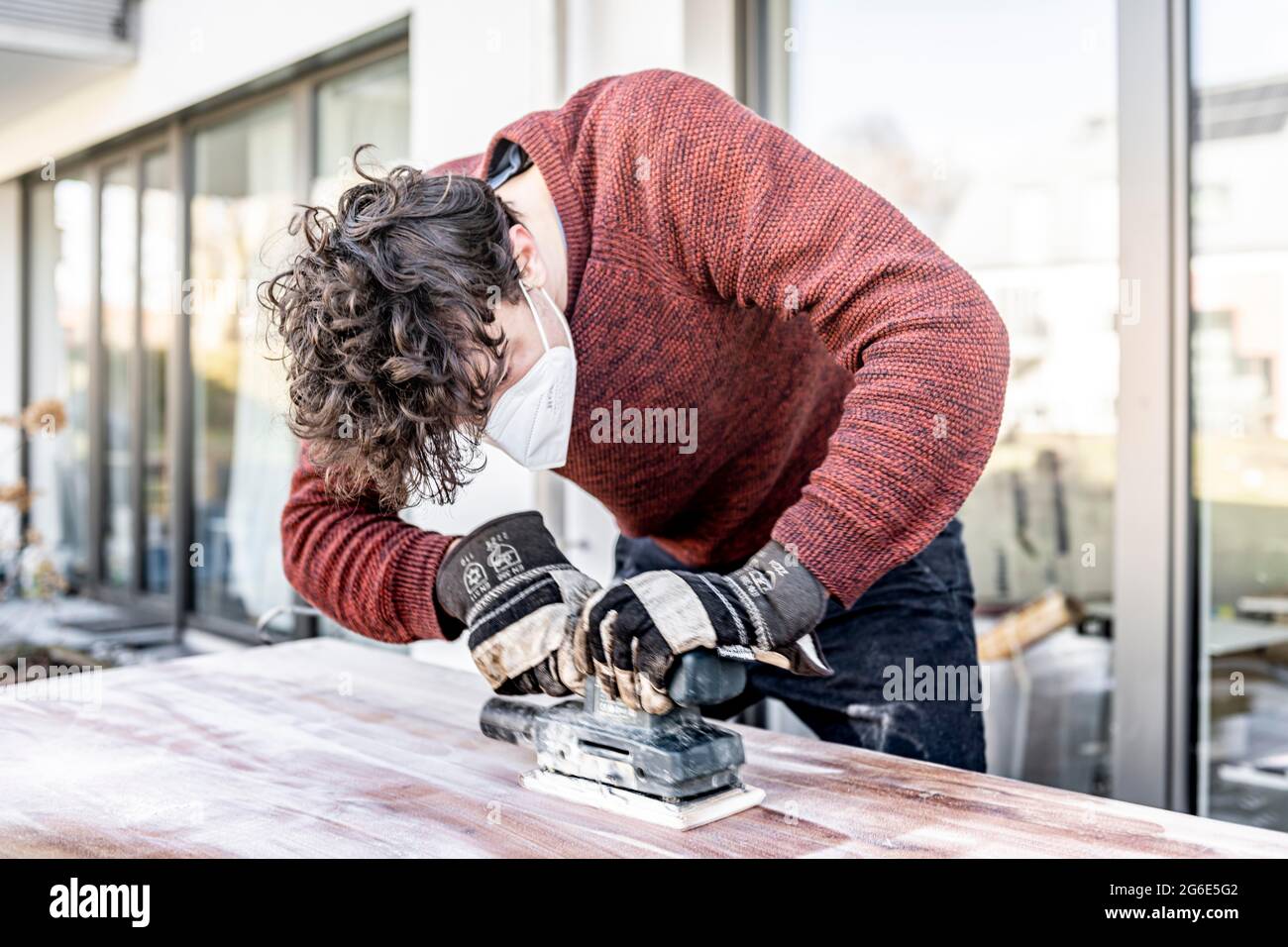 Junger Mann macht DIY, Schleiftisch mit einem Schleifer Stockfoto