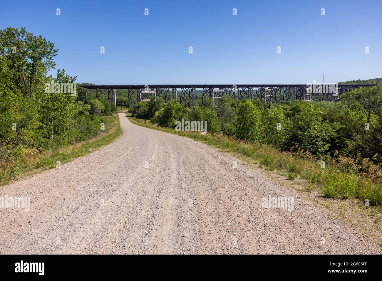 Eine Schotterstraße, die zu einer Eisenbahnbrücke führt. Stockfoto