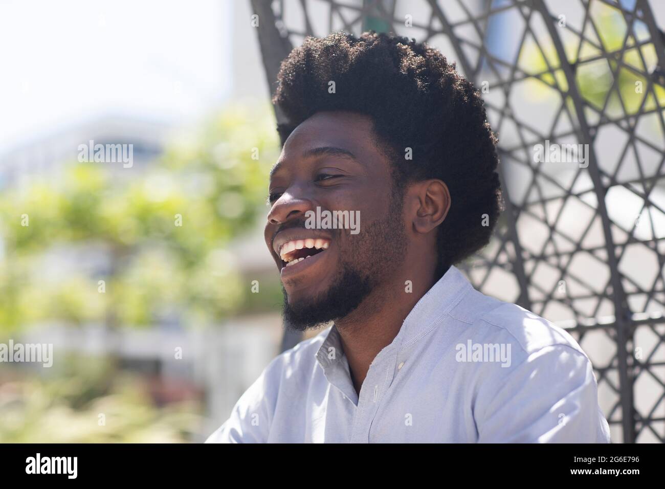Junger Mann, draußen, lachend und in die Zukunft schauend, Freiburg, Baden-Württemberg, Deutschland Stockfoto