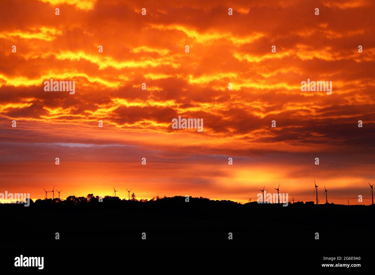 Sonnenuntergang, Windpark, Windturbinen auf Hügel, WKA, Windturbinen, Windturbinen am Kolonnenweg, Lochplattenweg, Gruenes Band, Grenzweg, ehemalige Stockfoto