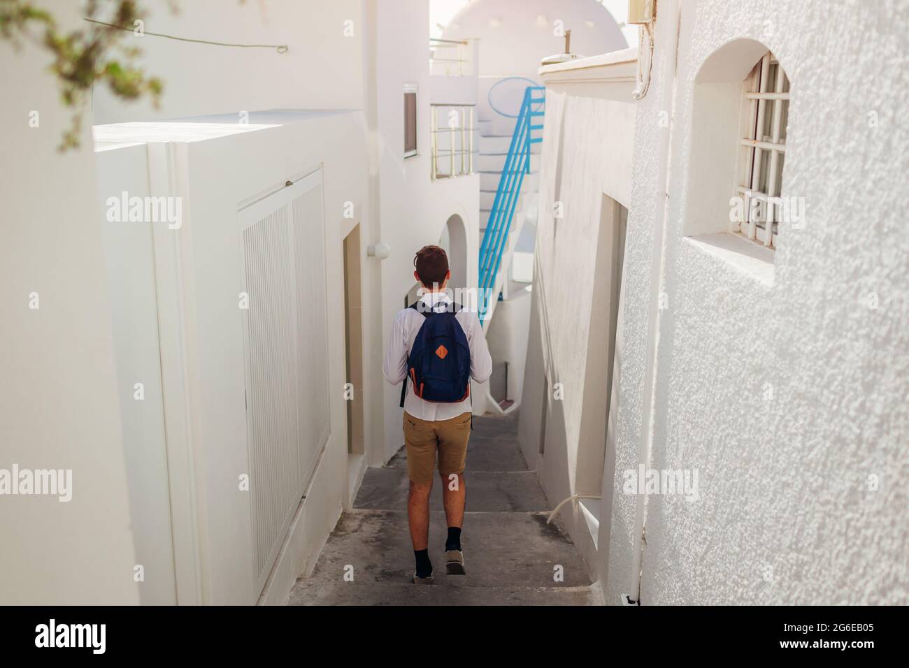 Santorini Tourist Mann zu Fuß entlang einer engen Straße in Fira, Thera, Griechenland zwischen traditionellen weißen Häusern. Sommerurlaub Stockfoto Santorini Tourist Mann zu Fuß entlang einer engen Straße in Fira, Thera, Griechenland zwischen traditionellen weißen Häusern. Sommerurlaub Stockfoto