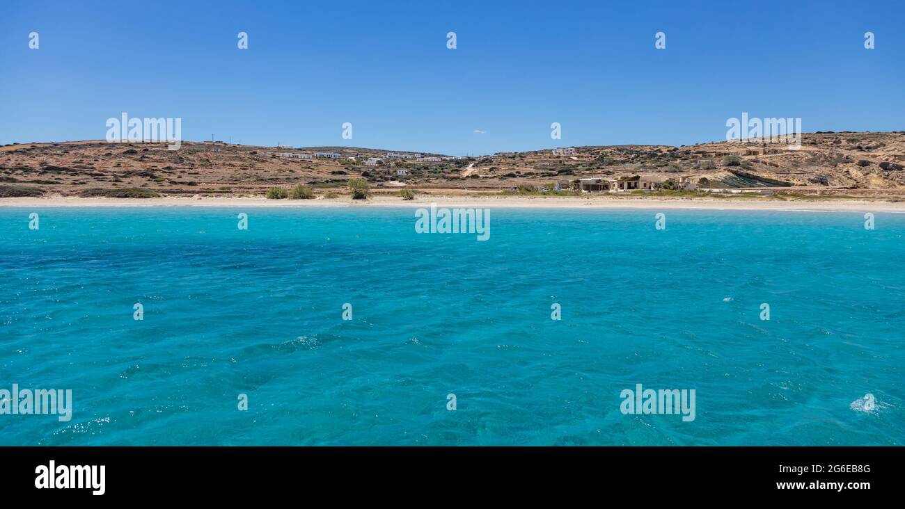 Kykladen Koufonisi Insel Griechenland. Sandstrand, türkisblaues, transparentes Meerwasser, Blick vom Meer. Typische Sommerhäuser an der Küste klaren Himmel. Stockfoto