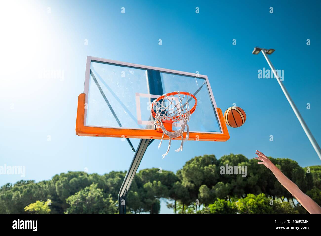 Die Hand des Sportlers, der Basketball spielt, wirft den Ball auf den Spielplatz, macht Hook Schuss von Jump Shot, Blick von hinten. Präzisionsschuss Stockfoto