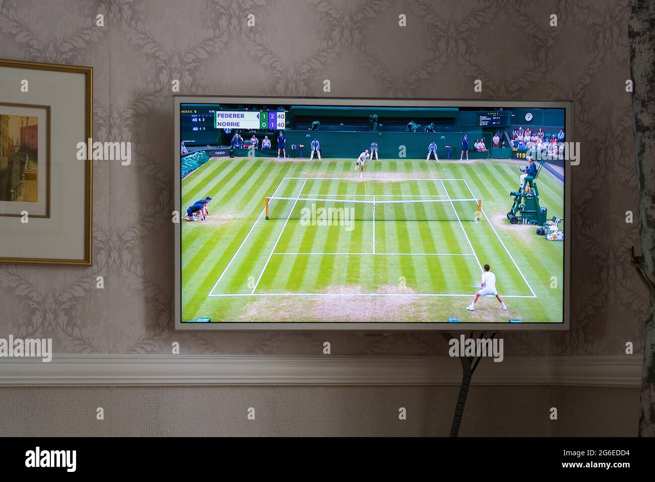 BBC-Berichterstattung über Wimbledon 2021 auf einem Flachbildfernseher an einer Wand in einer Lounge in einem Haus in England. Das angezeigte Spiel ist Federer vs Norrie. Juli 2021 Stockfoto