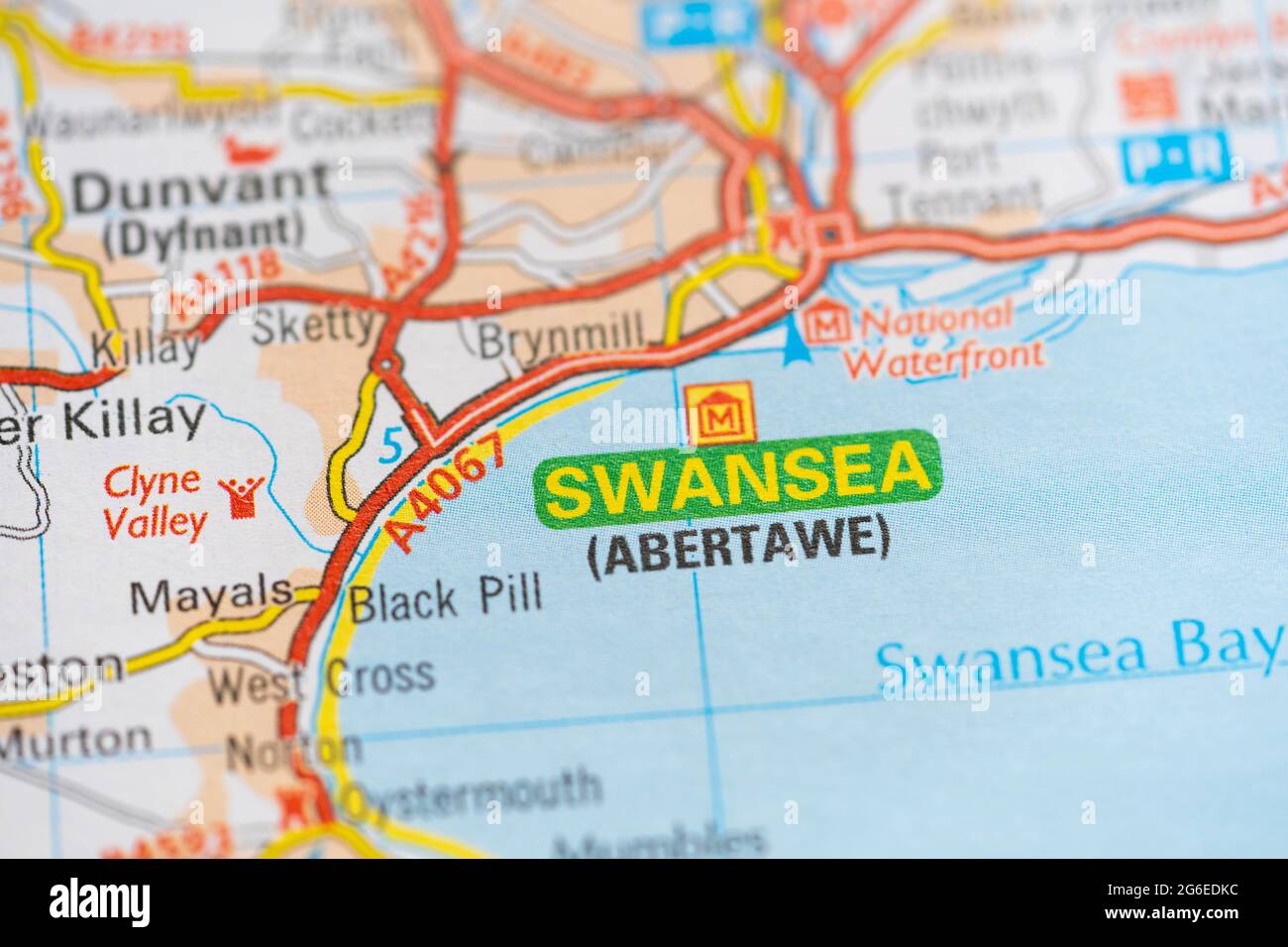 Makro-Nahaufnahme einer Seite in einem gedruckten Roadmap-Atlas mit zweisprachigem Text für die walisische Stadt Swansea (Abertawe) Stockfoto