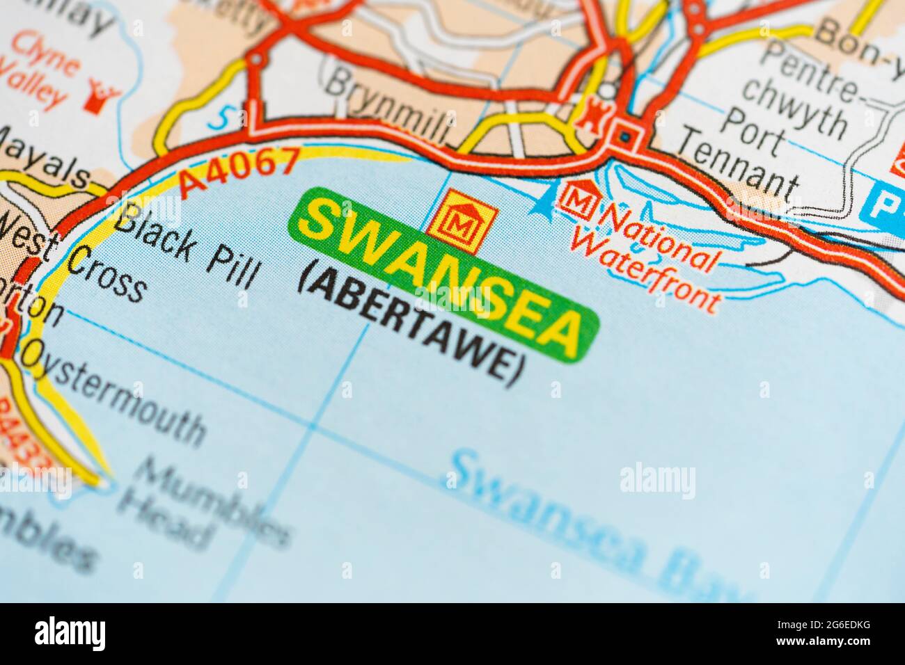 Makro-Nahaufnahme einer Seite in einem gedruckten Roadmap-Atlas mit zweisprachigem Text für die walisische Stadt Swansea (Abertawe) Stockfoto