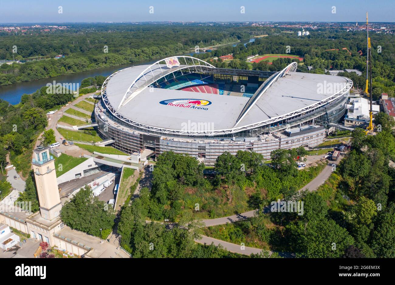 14. Juni 2021, Sachsen, Leipzig: Fußball: Bundesliga, RB Leipzig. Zwei Krane stehen in der Red Bull Arena. Das Heimgelände der Rasenballer wird umgebaut. Die Zuschauerkapazität wird von 42,558 auf 47,069 im Steh- und Sitzbereich erhöht. Die Außenseite des Stadions ist von einer schalldichten Fassade umgeben. Der Damm des ehemaligen Zentralstadions, das die Arena umfasst, wurde hinter dem historischen Glockenturm aufgeschnitten, um Platz für einen neuen Eingang zu schaffen. RB Leipzig investiert bis 2022 gut 60 Millionen Euro in den Umbau. (Luftaufnahme mit Drohne) Foto: Jan Woitas/dpa-Zentralbild/dpa Stockfoto