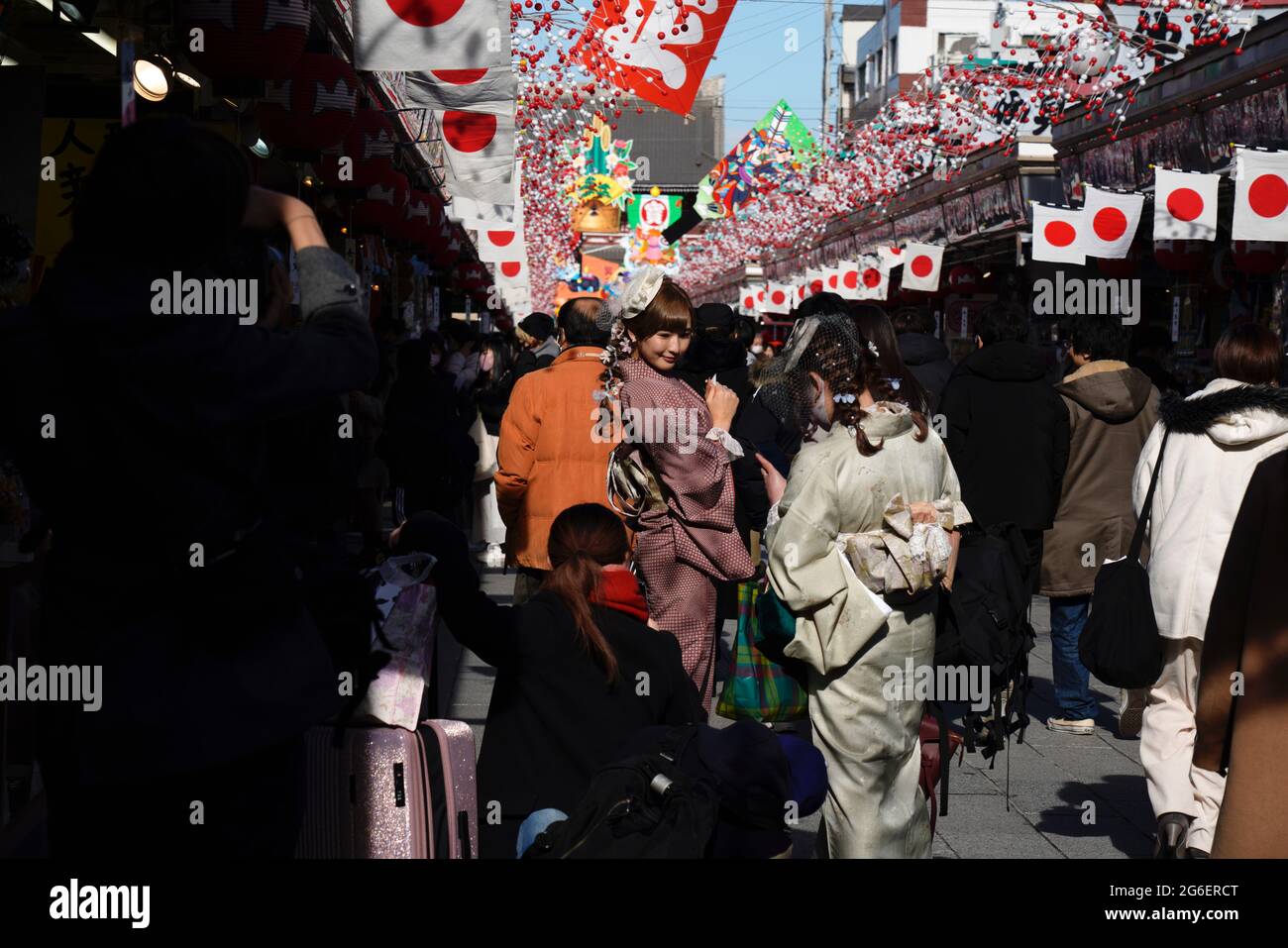 Besucher posieren für Fotos an den nakamise dori-Ständen des Sensoji-Tempels während der Neujahrsfeiertage in Asakusa, Tokio, Japan. Stockfoto